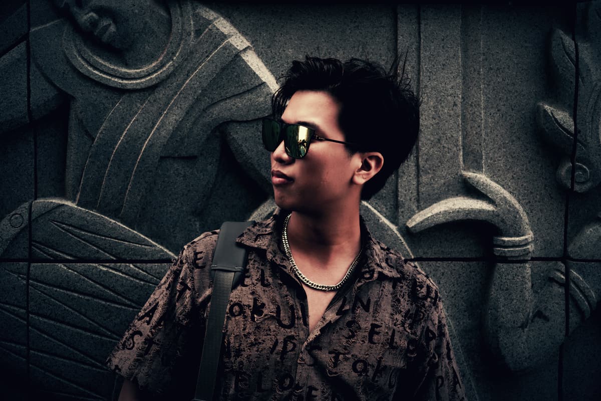 Long Bui photographed against a carved stone wall